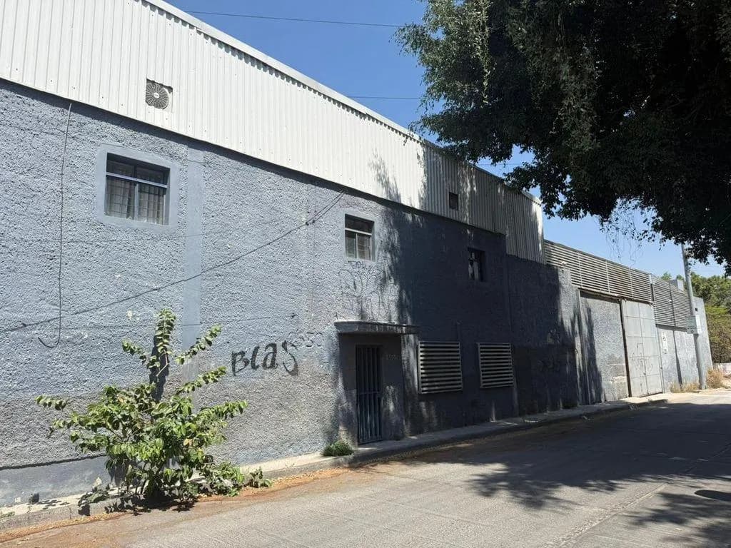MN 26,175,000Bodega en venta la nogalera $26’175, 000 pesos* Ajonjolí #2530, La Nogalera, C. P. Ver datos, Guadalajara, Jalisco. 1687. 09 m² de terreno. 2140 m² de construcción. Amplia bodega localizada a 2 minutos de Lázaro Cárdenas Oriente, frente al Parque de la Liberación. La bodega cuenta con área de carga y descarga, así como espacio de maniobras para el aparcamiento de vehículos. Área de comedor con cocina integral conectada a 2 espacios administrativos, un baño con tarja de acero inoxidable y regadera. Escaleras en el área de maniobras que conectan con un espacio de oficinas dividido en secciones para mayor privacidad. Bodega de almacenamiento con techo de láminas galvanizadas, estructura conformada por armaduras tipo nave industrial y conexión con un área administrativa de 7 privados y un espacio de site. El área administrativa conectada al almacenamiento cuenta con entrada independiente desde la calle. Zonificación: Área de Renovación Urbana / Comercio y Servicios de Impacto Bajo. Usos permitidos: H1 – H2 – H3 – H4 – H5 – cs1 – cs2 – I1 – E1 – E2 – ea – anp – pc – prh. Usos condicionados: cs3 – I2 – E3 – rie – ris – rit – arn. Incluye: Corriente eléctrica trifásica y tablero eléctrico con control por secciones de la propiedad, instalación para cámaras de seguridad. *Precio no incluye iva. wig: pgoamtr - Fotografía 1